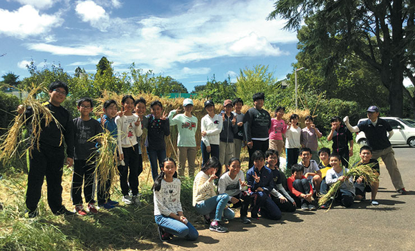 千葉明徳_「土と生命の学習」で、稲刈りを終えた生徒たち