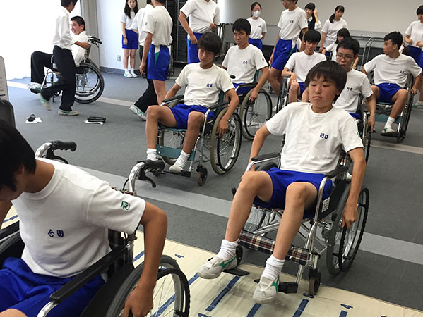 獨協埼玉_初めての車椅子体験に真剣な表情の生徒たち（上は2019年度の様子）