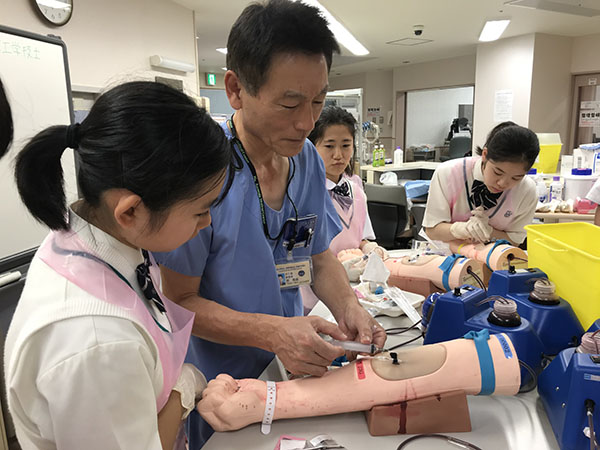 江戸川取手_亀田総合病院で、本物の注射器を使って採血を体験する中学生たち