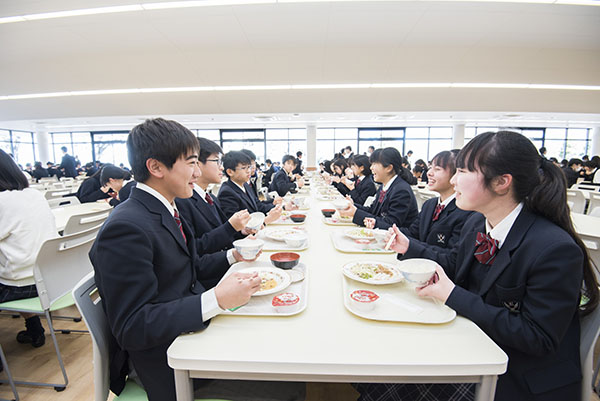 麗澤_美味しく楽しいランチタイム（写真はコロナ禍以前のもの。現在は中・高の食事時間を分け、座席間にパーテーションを設置して間隔を開けて着席している）