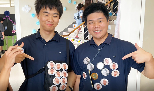 城西大城西_これでもかという数の、神杉校長の顔の缶バッジ！　二人の表情からは、同校に流れる空気感が伝わってくる